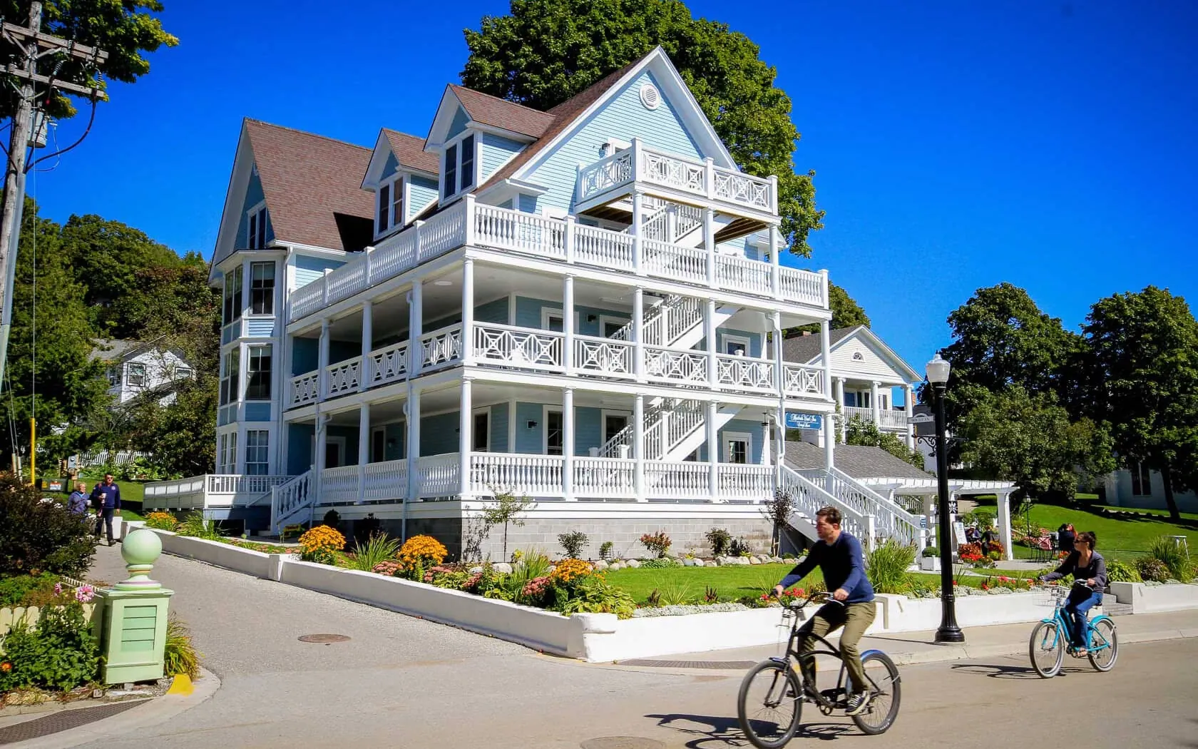 A cyclist biking in front of the Harborview Hotel on the street.